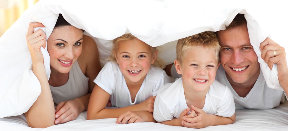 Familie in gemütlichem Bett im Urlaub in Flachau