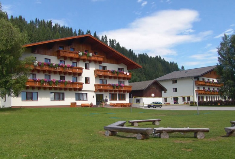 Jugendsporthotel Stadler mit Lagerfeuer und Volleyball-Platz im Sommer